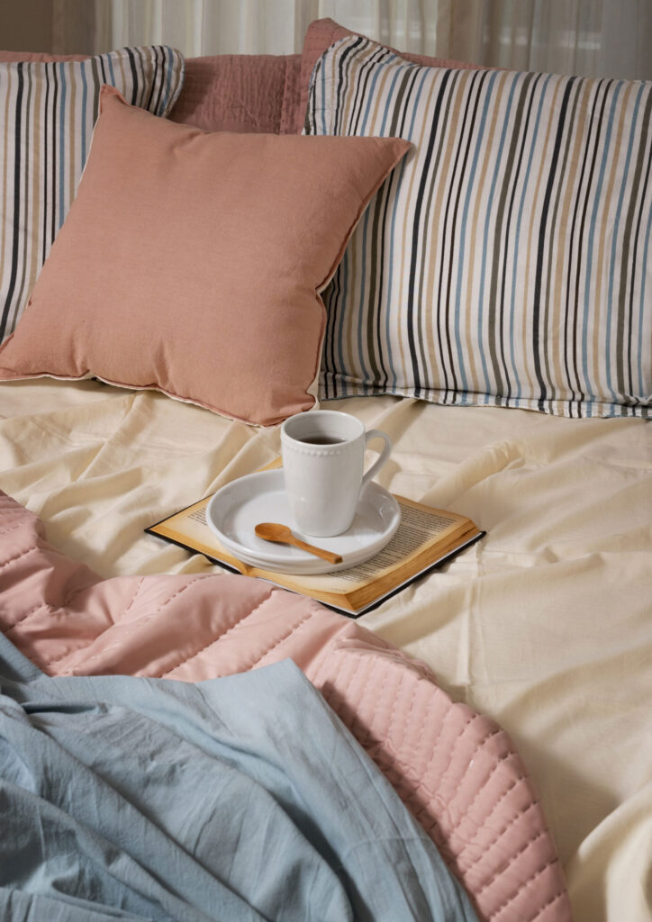 high angle cozy bed arrangement with coffee cup